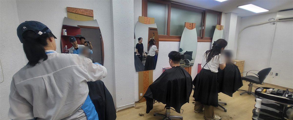 정신요양원 미용실에서 봉사자들이 머리를 다듬어 드리는 모습